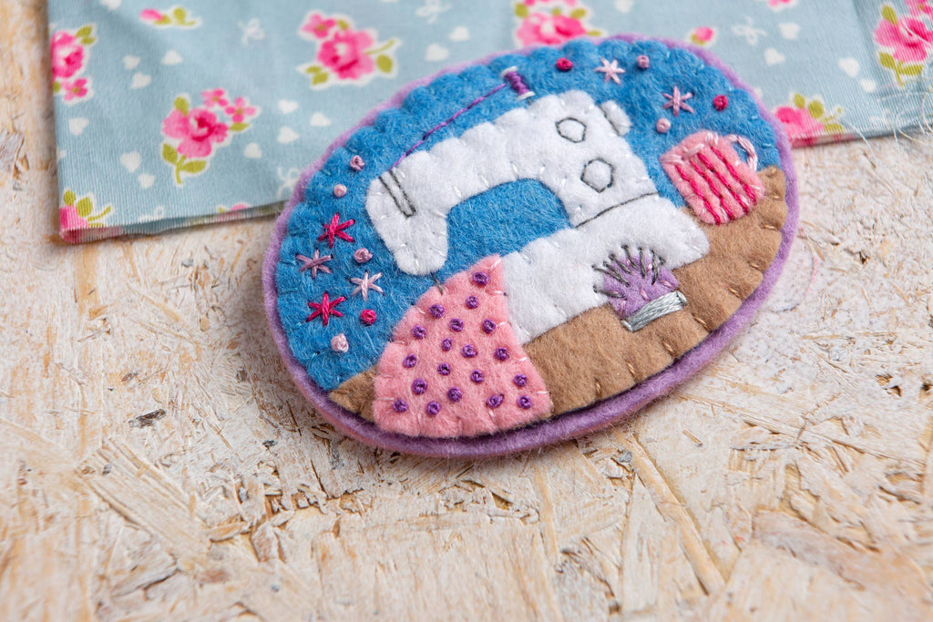 Felt brooch with a sewing machine design on a wooden surface