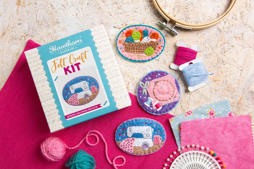Felt craft kit with embroidered items and sewing accessories on a textured surface
