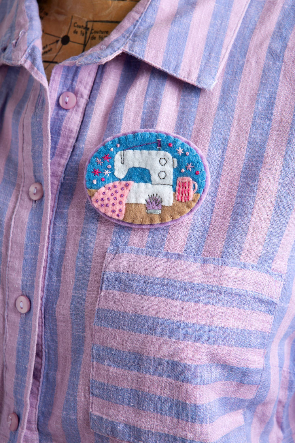 Striped shirt with a sewing machine patch on a wooden surface