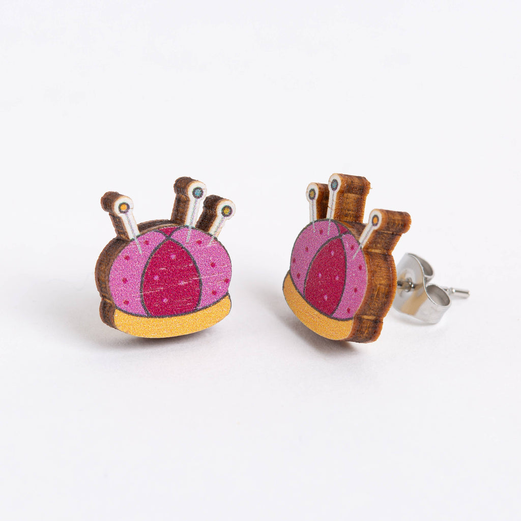 Pair of earrings with pink and yellow design on a white background