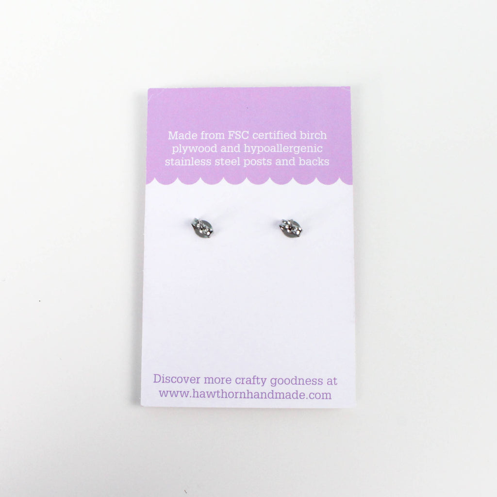 Pair of earrings on a branded card with product details on a white background