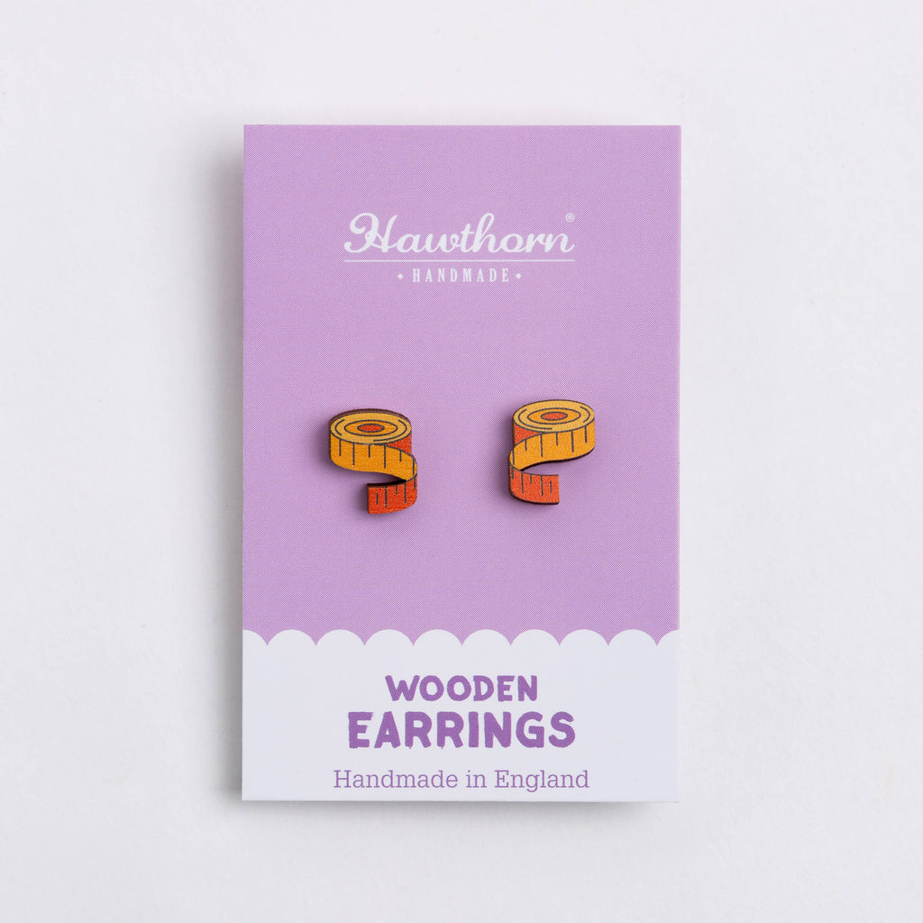 Purple card with wooden earrings on a white background