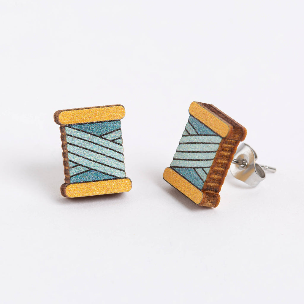 Wooden spool earrings with blue and green pattern on a white background