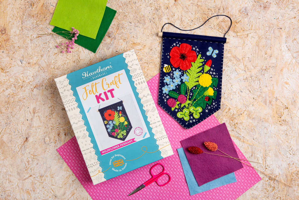 Floral felt craft kit with materials on a textured surface