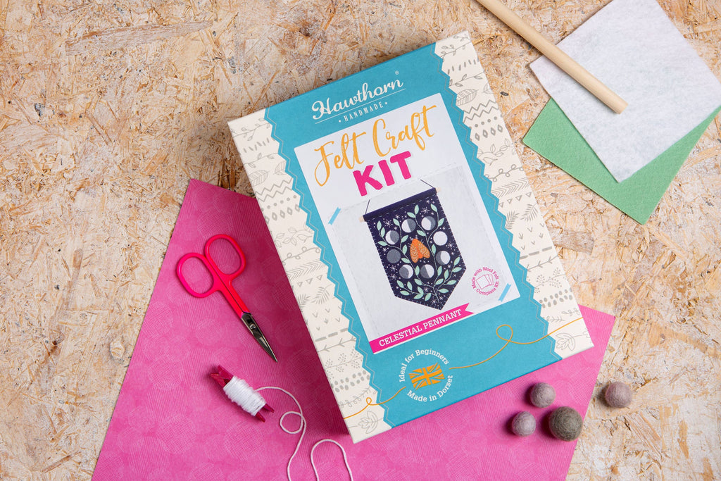 moth and moon pennant Craft Kit on a textured surface with craft supplies.