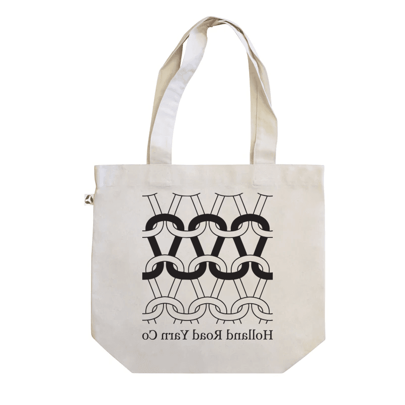 Beige tote bag with black geometric pattern and text on a white background