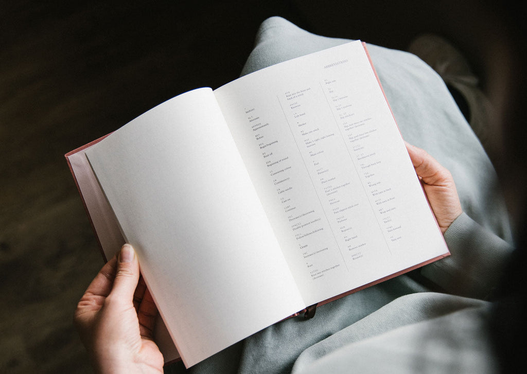 Person holding an open book with text on a dark background