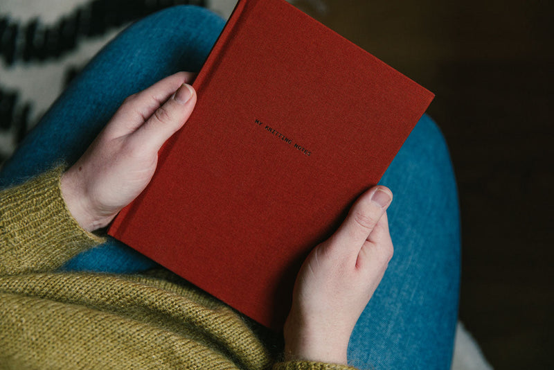 Red book held by a person with a blurred background