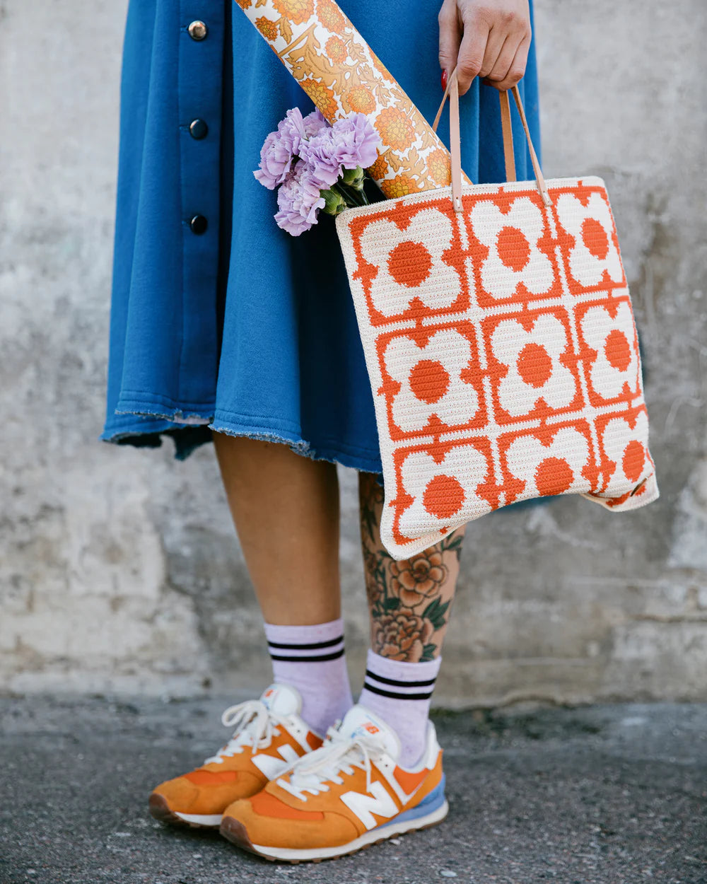Person holding a floral crochet tote bag